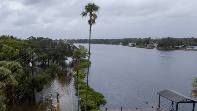 Residents walk down flooded street after Hurricane Idalia in Tarpon Springs, Florida