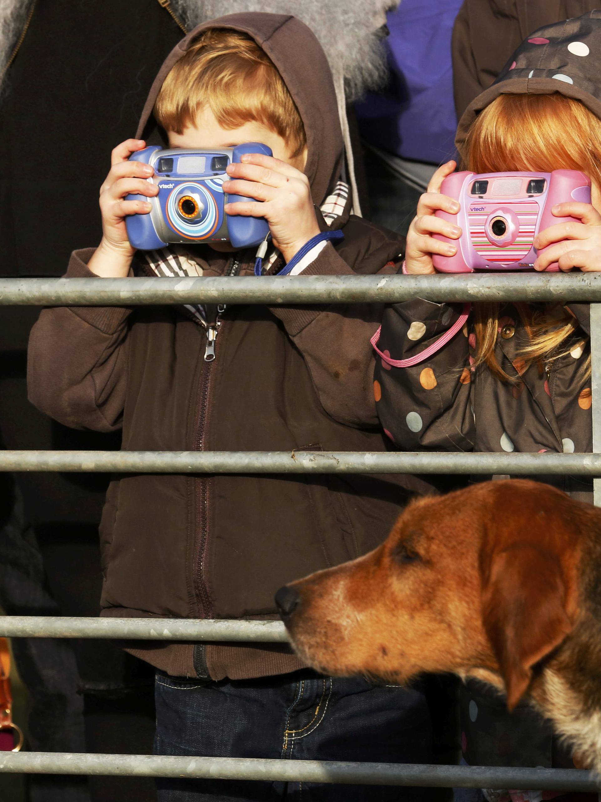 Young photographers take photographs of hounds as the New Forest Hunt gathers at at Boltons Bench for the annual Boxing Day hunt in Lyndhurst