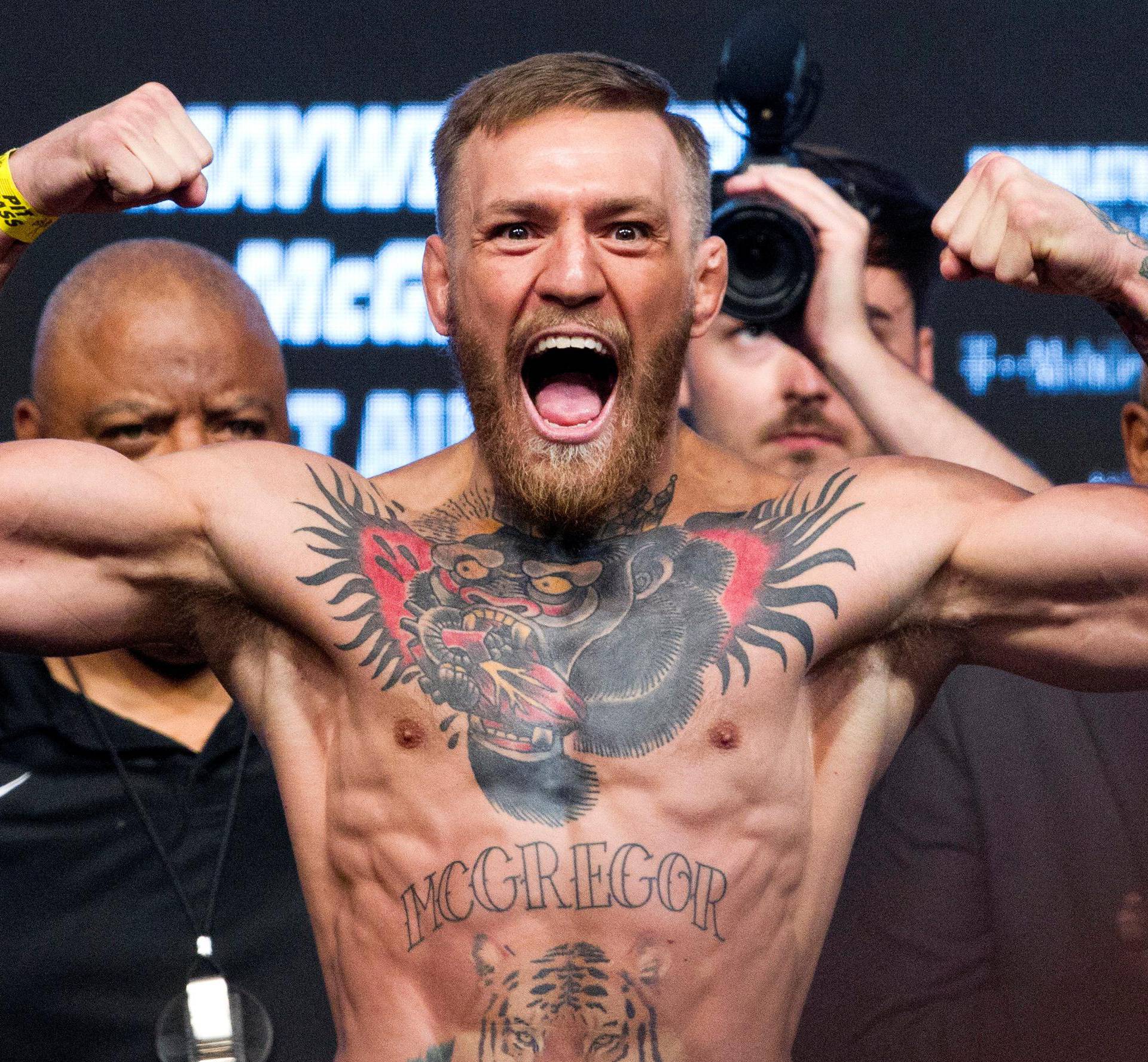 UFC lightweight champion Conor McGregor of Ireland poses on the scale during his official weigh-in at T-Mobile Arena in Las Vegas