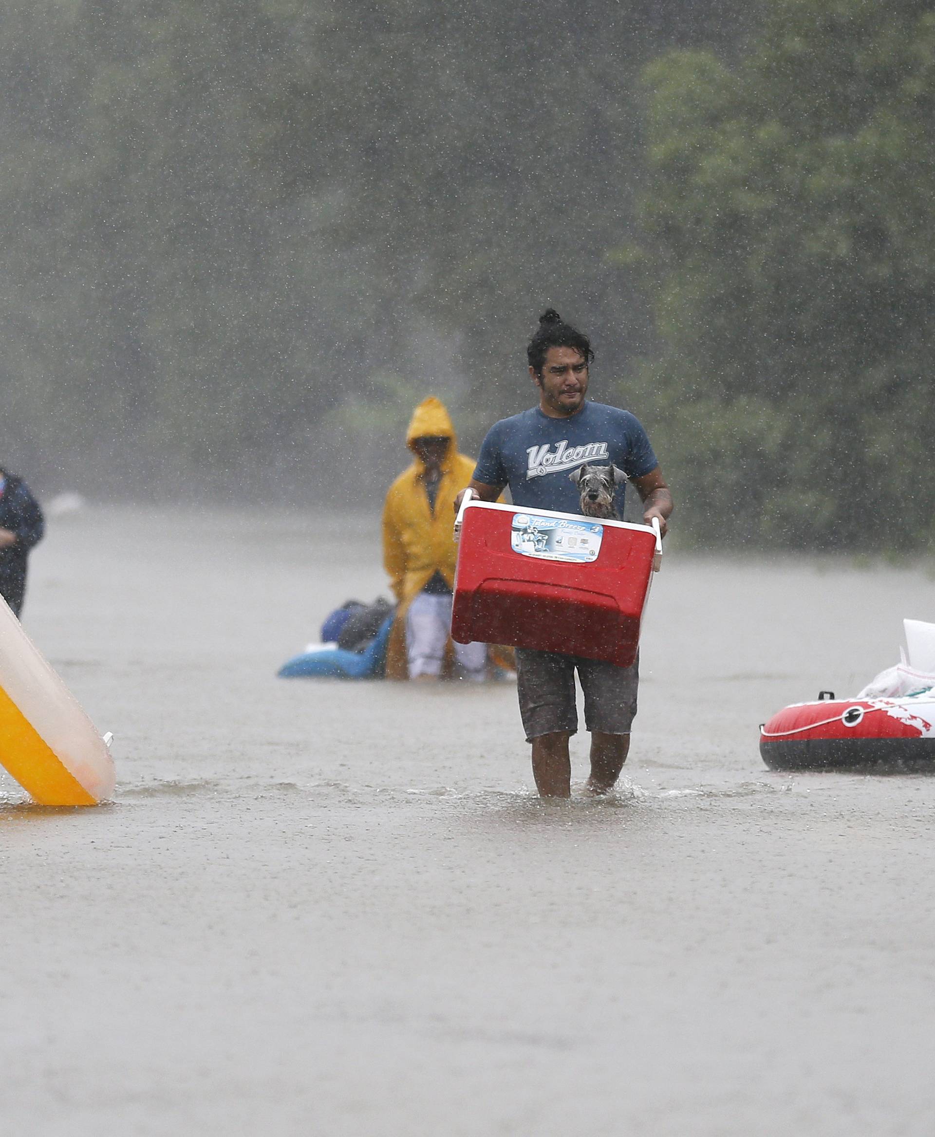 Residents wade through flood waters from Tropical Storm Harvey in Beaumont Place, Houston