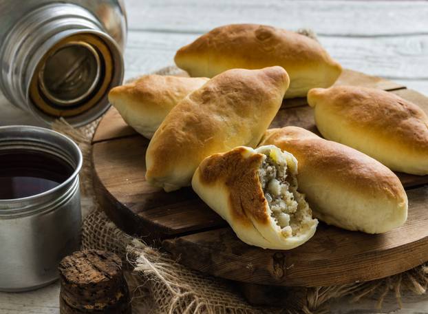 Russian pirozhki ,baked patties, on wooden cutboard