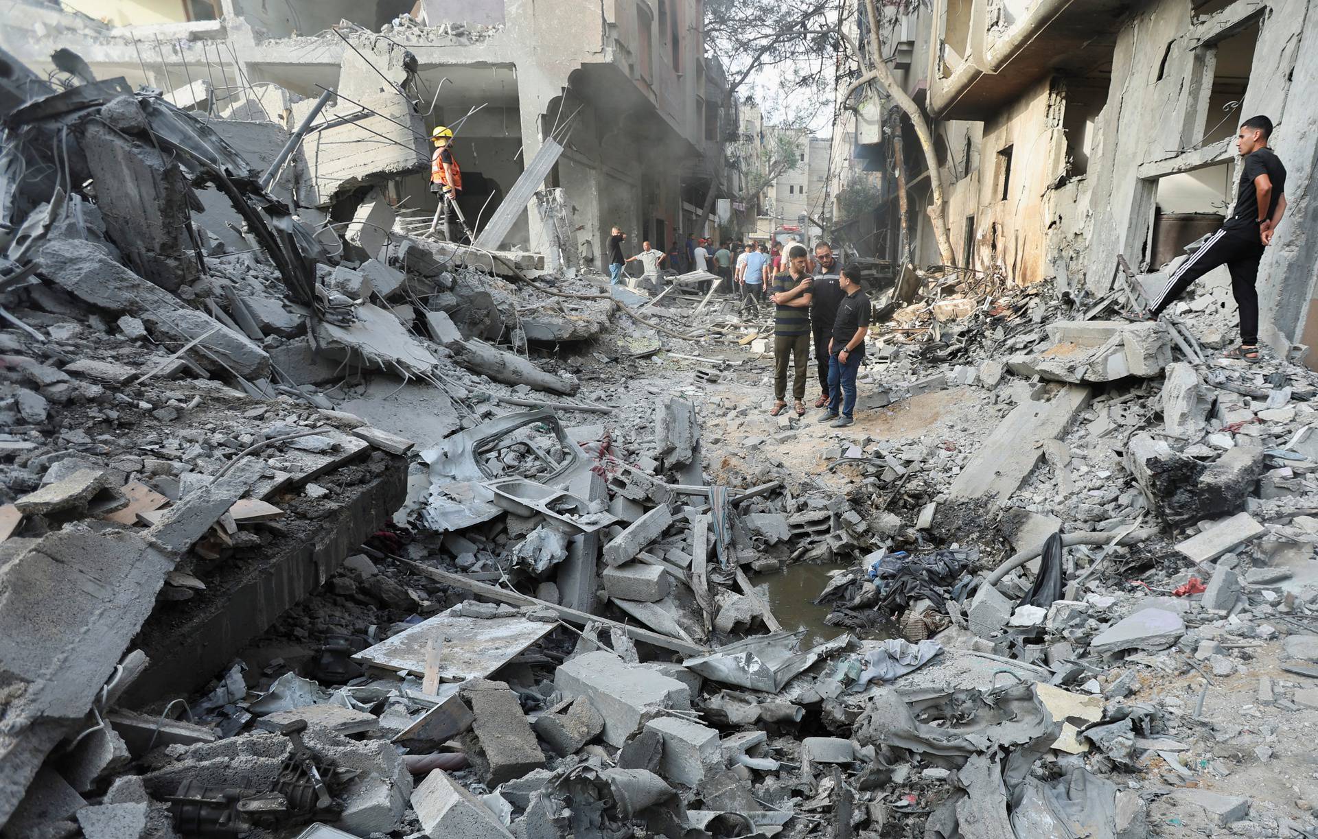 Palestinians inspect a house hit in an Israeli strike, in Nuseirat refugee camp