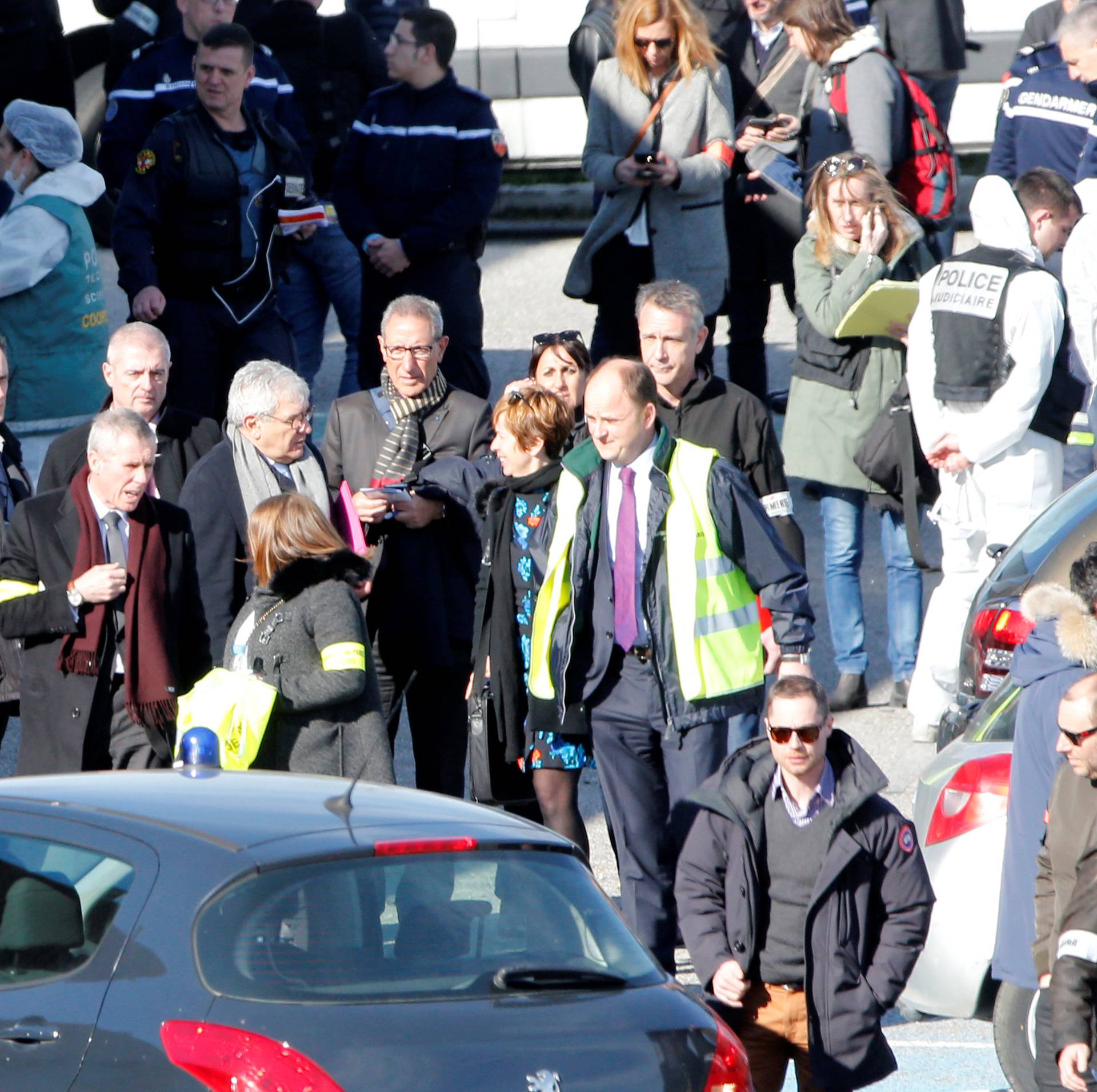 Police officers and investigators are seen in front of a supermarket after a hostage situation in Trebes