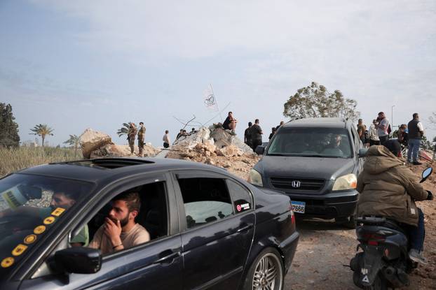 Displaced people cross the bridge linking southern Lebanon to the rest of the country, which was hit earlier in an Israeli strike, in Qasmiyeh