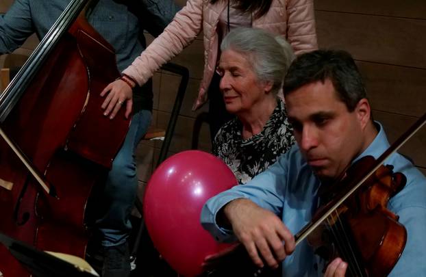 A deaf woman holds a balloon to feel vibrations of the music during a concert of the Danubia Orchestra in Budapest