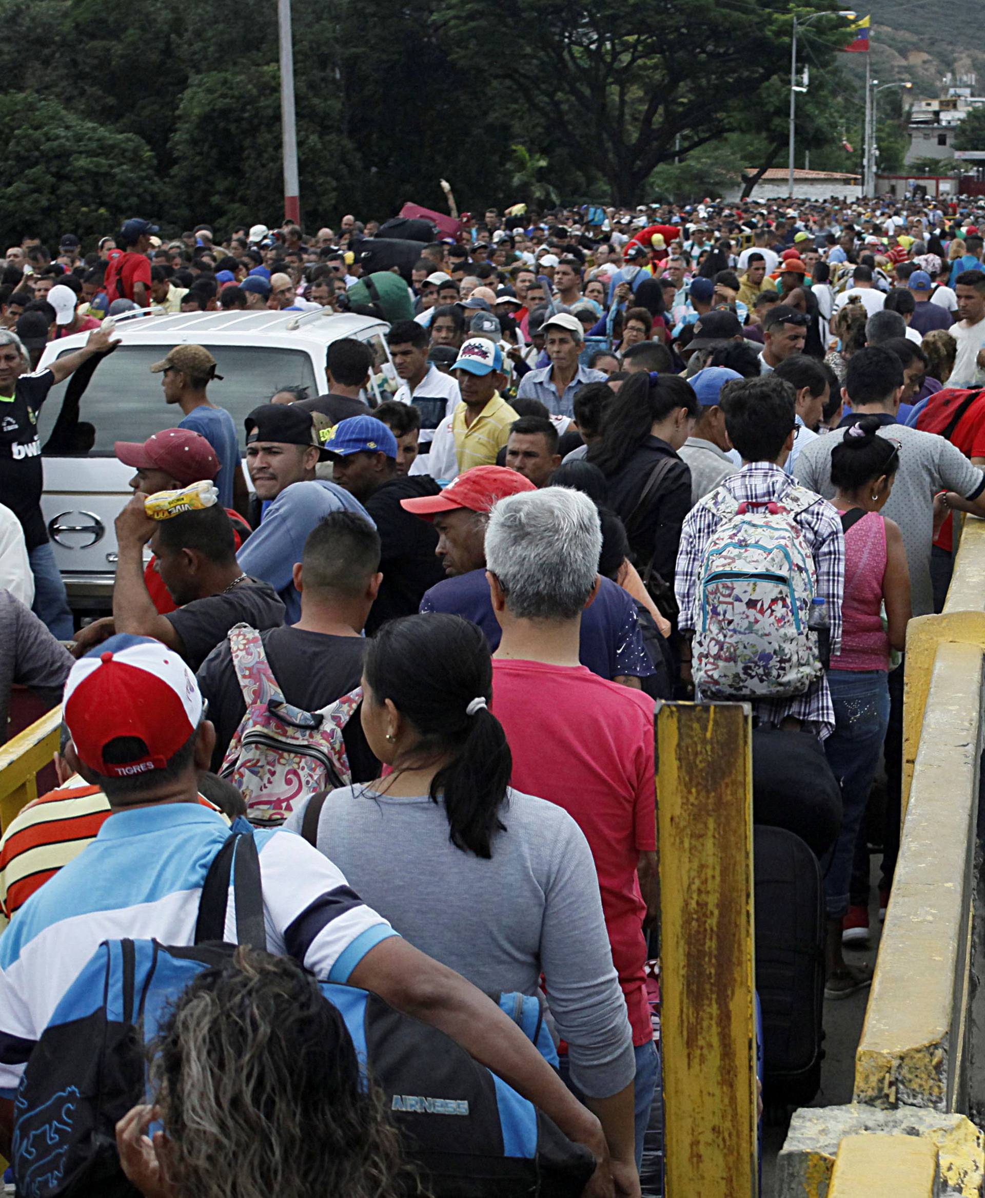FILE PHOTO: A man gets off the bridge as people queue to try to cross the Venezuela-Colombia border through Simon Bolivar international bridge in San Antonio del Tachira