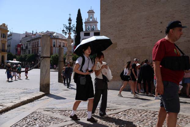 People walk during a heatwave, in Seville