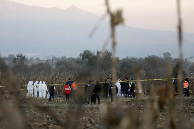 Forensic technicians and rescue personnel stand at the scene where the helicopter transporting Martha Erika Alonso, governor of the state of Puebla, and his husband Senator Rafel Moreno Valle crashed, in Coronango