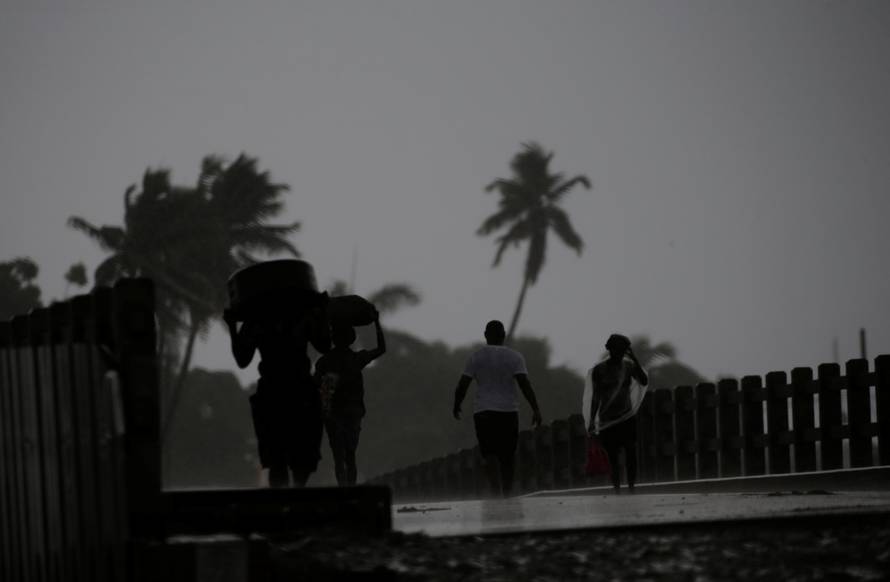 People walk across a bridge in the rain brought by Hurricane Irma in Cap-Haitien