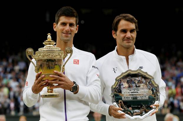 FILE PHOTO: Winner, Novak Djokovic of Serbia and runner up Roger Federer of Switzerland pose with their trophies after their Men