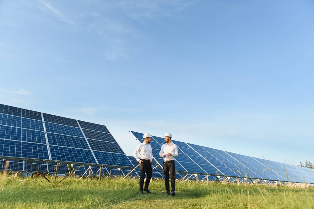 The,Solar,Farm(solar,Panel),With,Two,Engineers,Walk,To,Check