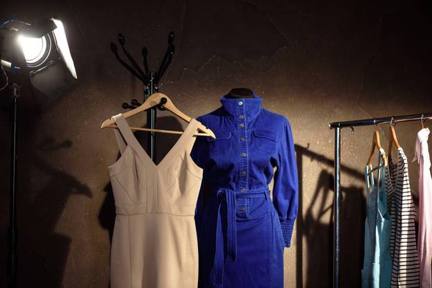 Fashionable clothes hanging in dressing room