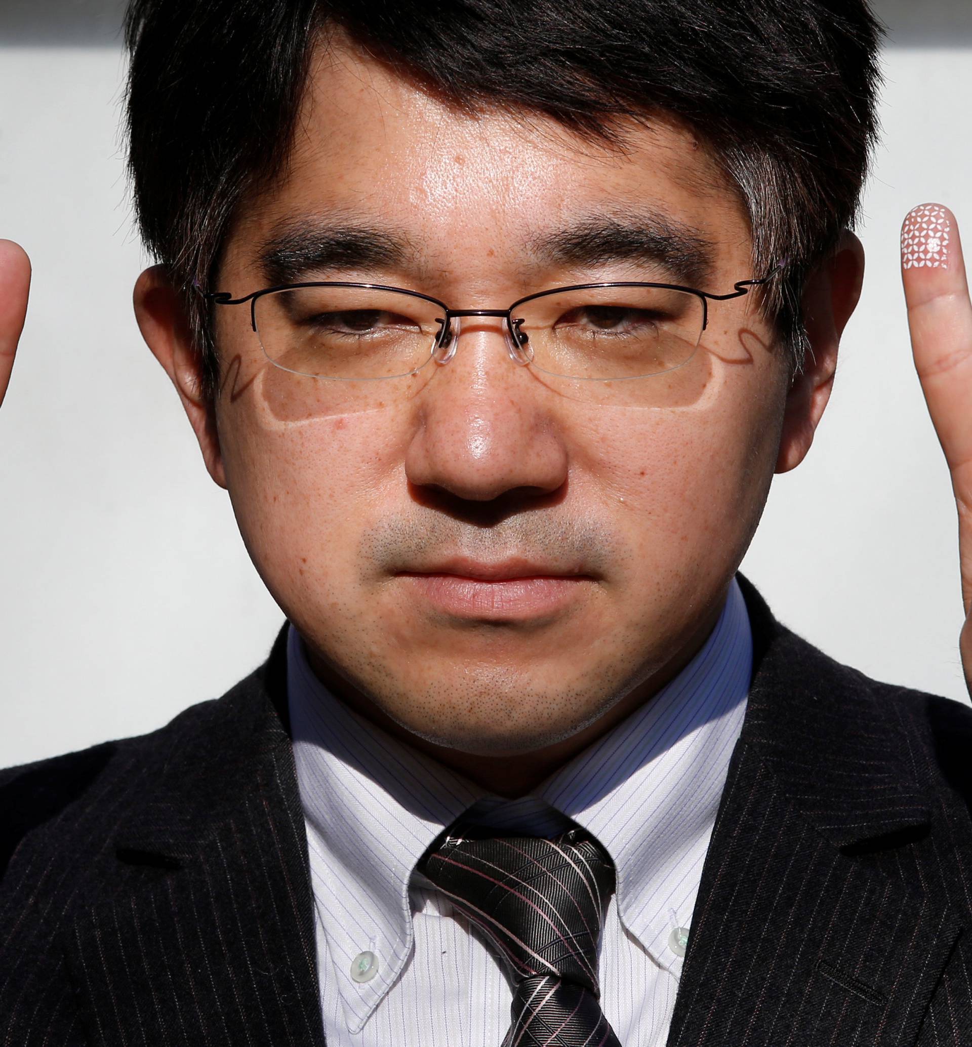 Echizen, a professor at Japan's National Institute of Informatics, gestures during a demonstration of his experiment for Reuters in Tokyo