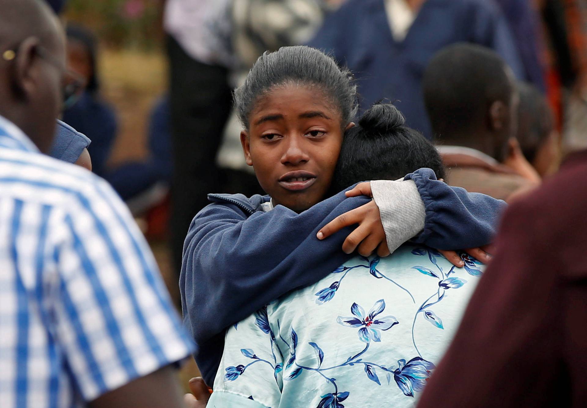 A student embraces her parent following a fire which burnt down one dormitory of Moi Girls school in Nairobi