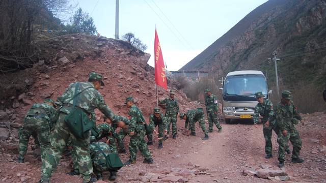 Paramilitary policemen remove rocks after an earthquake injured over 60 people in Chamdo