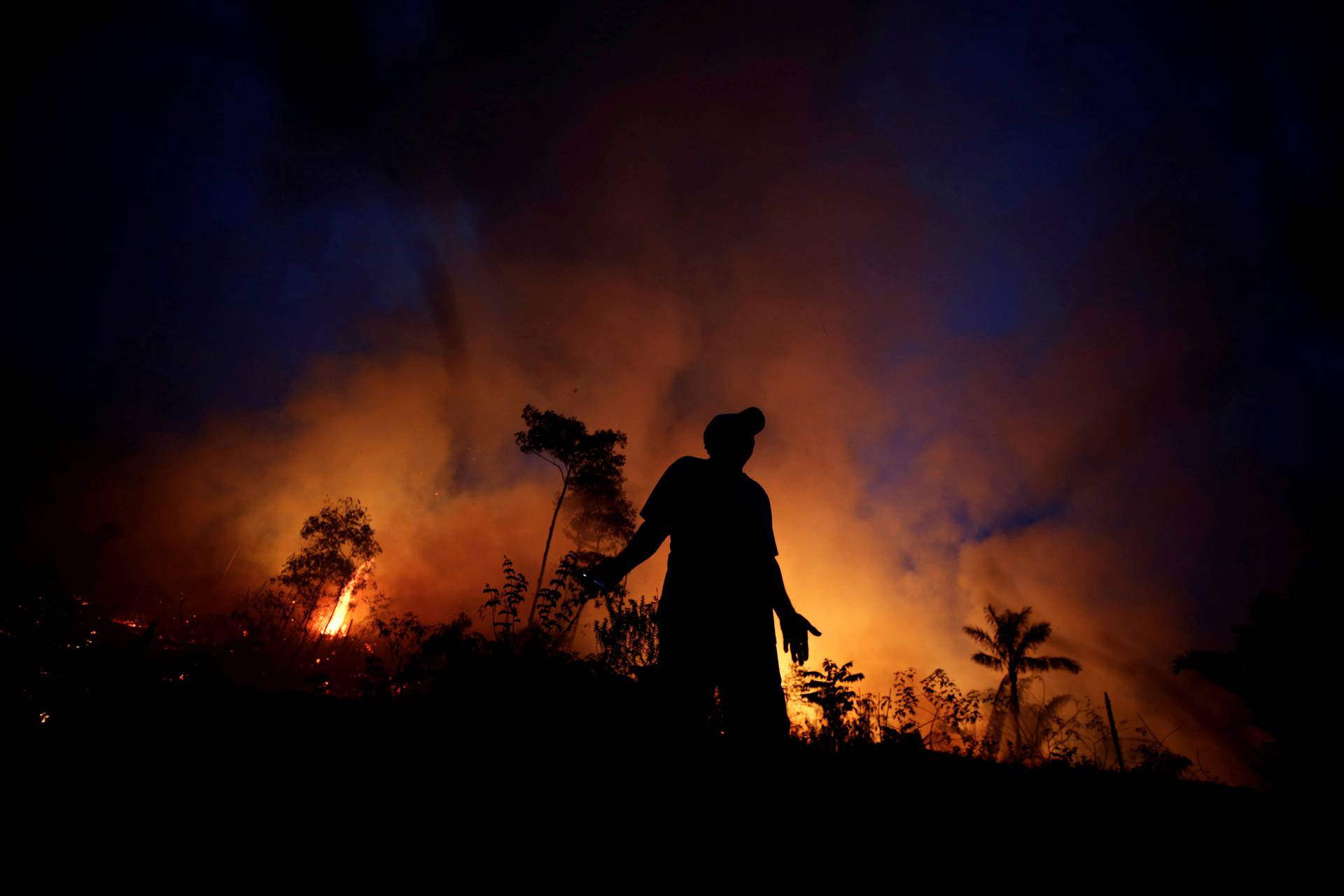 FILE PHOTO: A fire burns as back burning is used to create a firebreak to stop the progress of a fire at a tract of the Amazon jungle in Apui