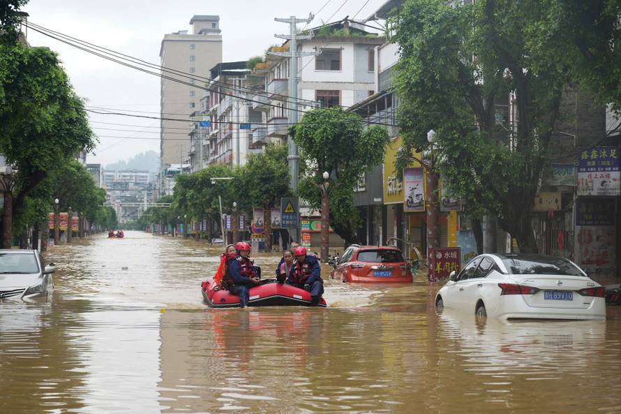 Rescue workers evacuate flood-affected residents with a boat in Rongjiang county, Guizhou