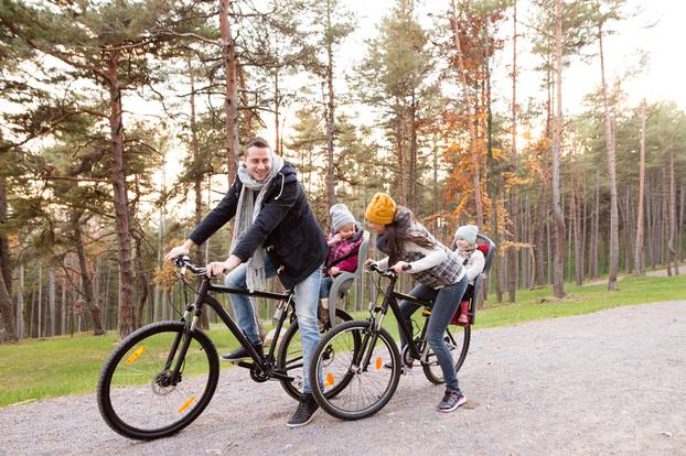 Young,Family,In,Warm,Clothes,Cycling,In,Autumn,Park