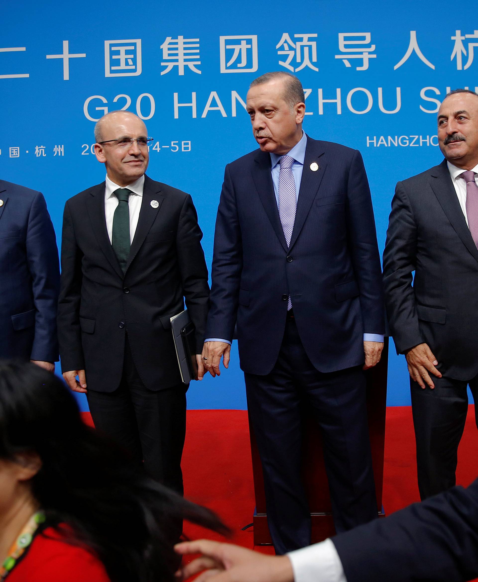 A security agent reacts as a woman tries to have a pictures taken in front of Turkey's President Tayyip Erdogan and his delegation after the closing of G20 Summit in Hangzhou
