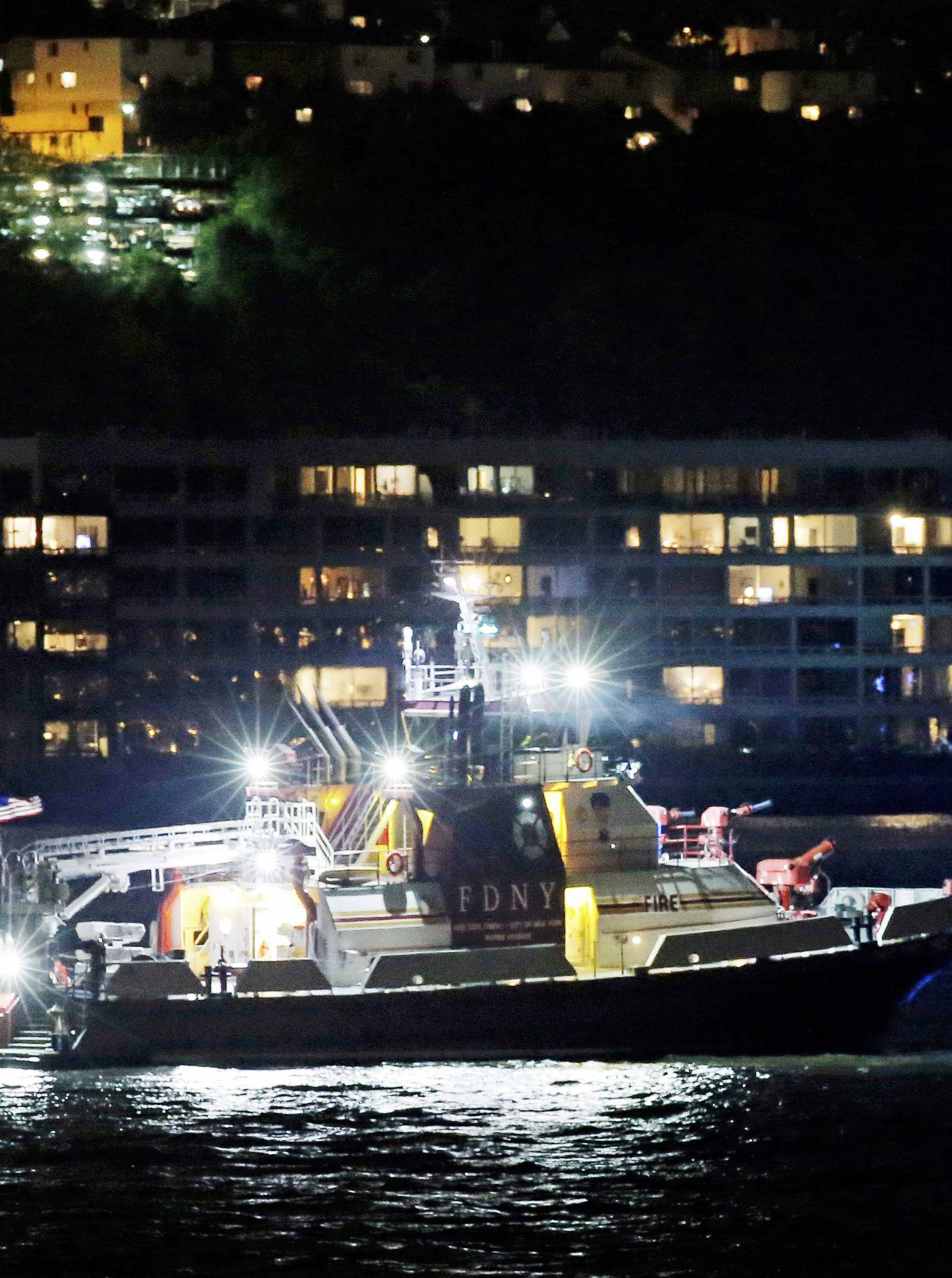 An FDNY fire department boat searches the Hudson River for the wreckage of a vintage P-47 Thunderbolt airplane that crashed in the river in New York City