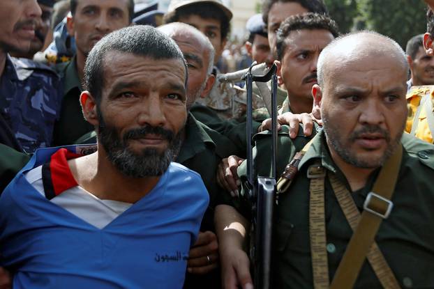 Police officers escort Muhammad al-Maghrabi, 41, who was convicted of raping and murdering a three-year-old girl, to the execution site, in Sanaa