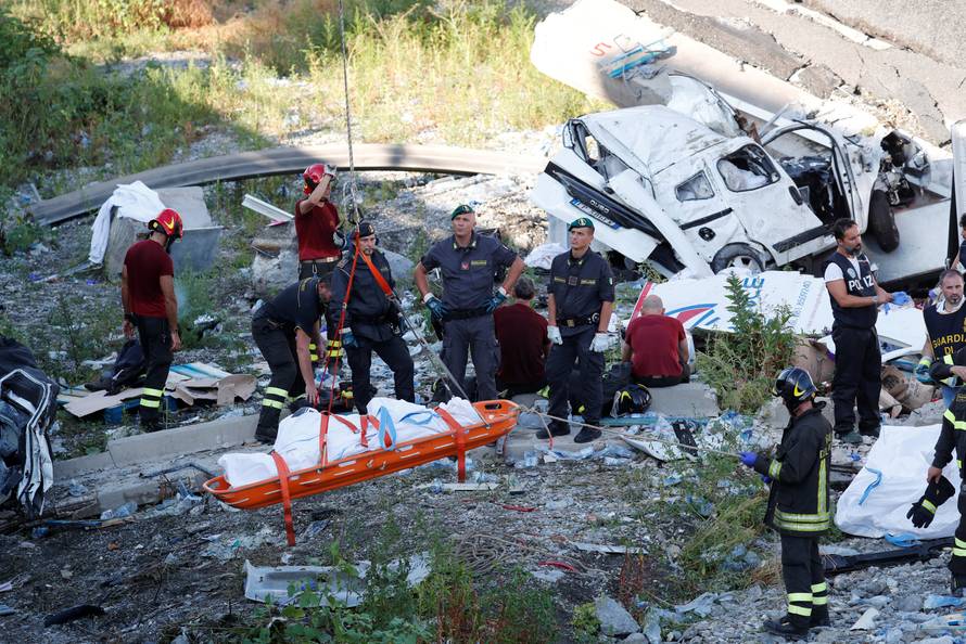 Rescue workers recover a body at the site of the collapsed Morandi Bridge in the Italian port city of Genoa