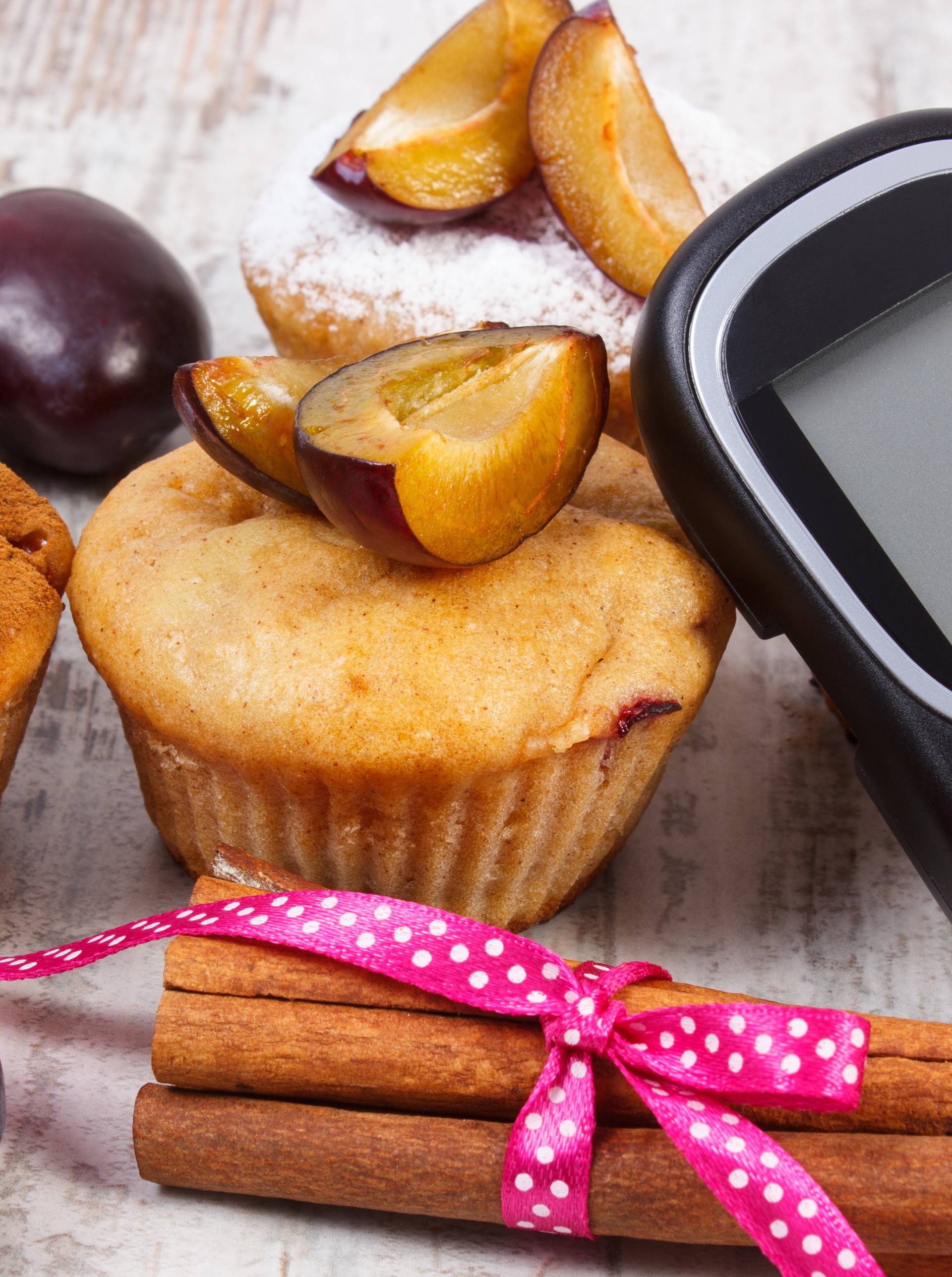 Glucometer, muffins with plums and cinnamon sticks, diabetes, delicious dessert