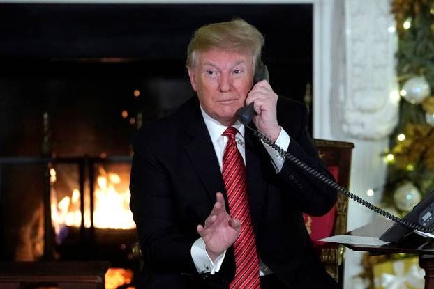 U.S. President Trump participates in NORAD Santa tracker phone calls from children, in the State Dining Room of the White House in Washington