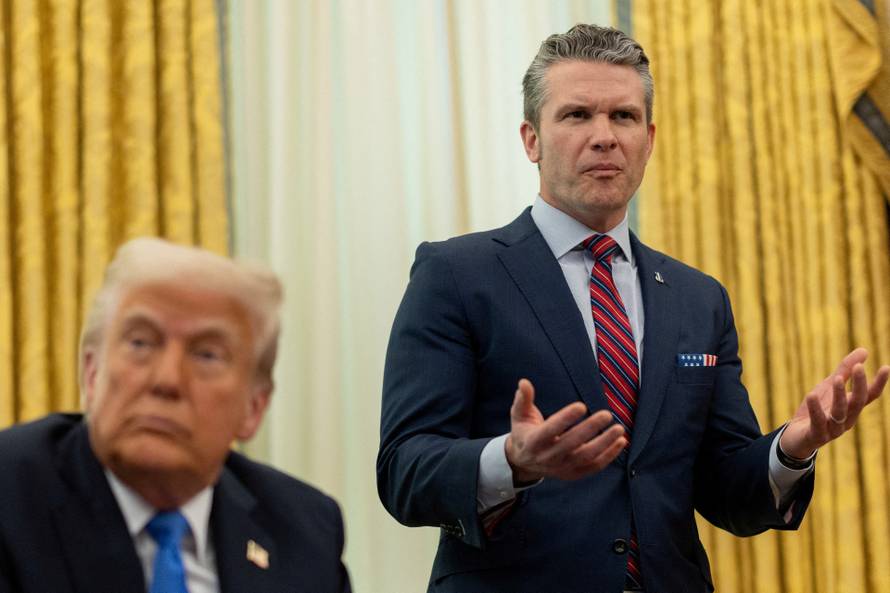 FILE PHOTO: U.S. Defense Secretary Pete Hegseth speaks next to President Donald Trump, in the Oval Office at the White House, in Washington, D.C.
