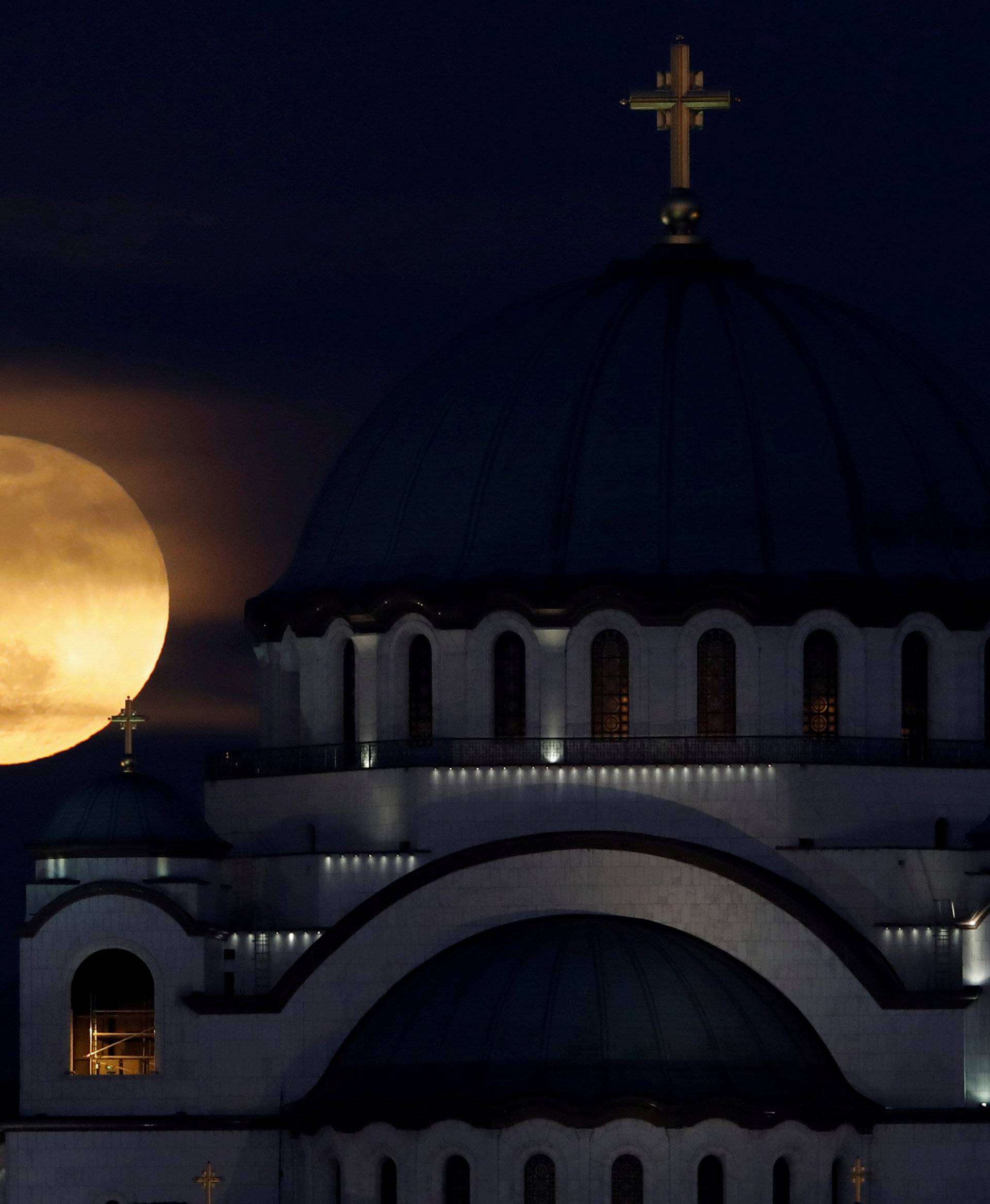 A full moon rises behind St. Sava temple in Belgrade