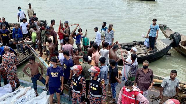 Dead bodies are seen piles up on a boat after a passenger ferry capsized in the river Buriganga in Dhaka