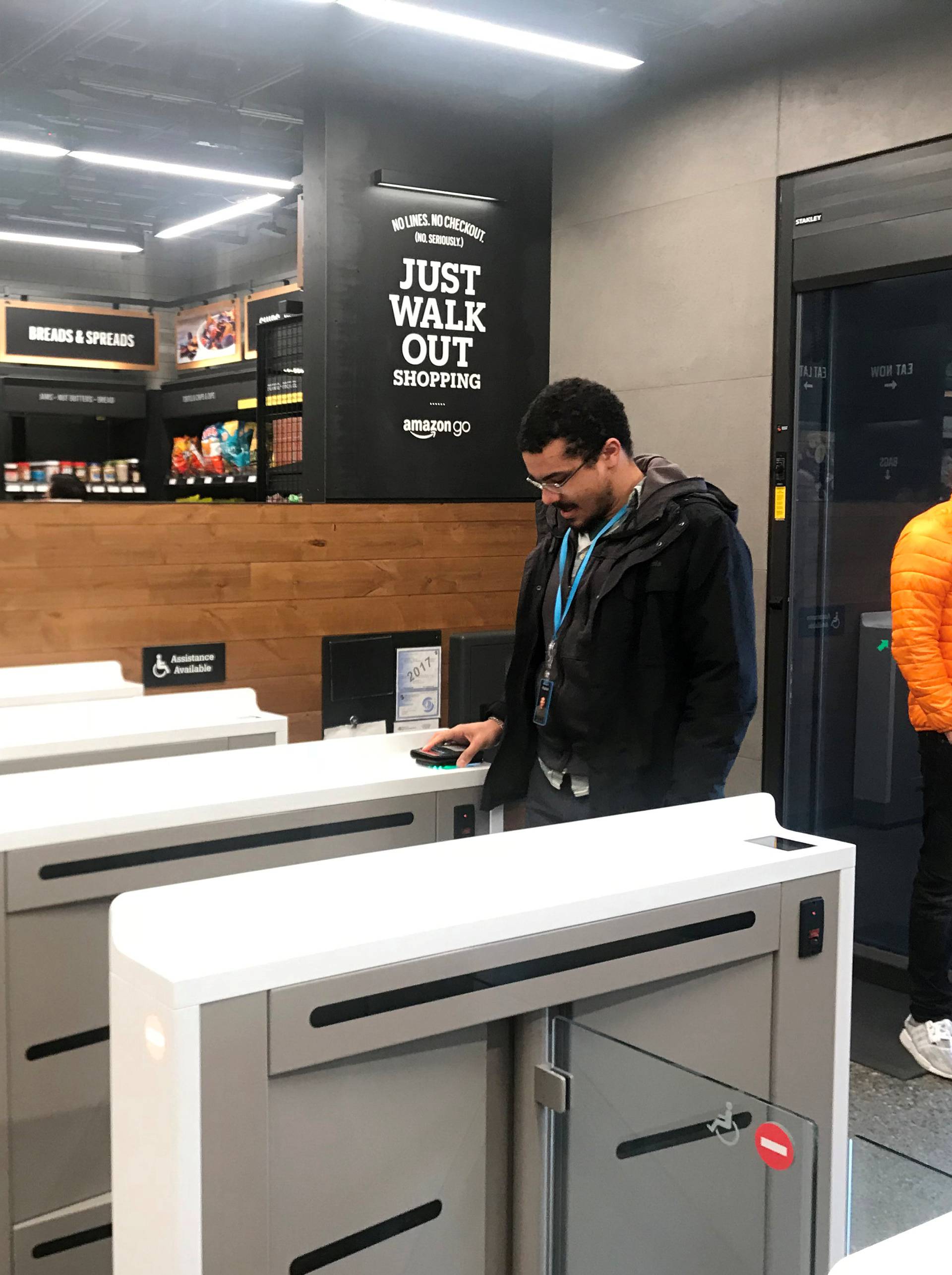 A shopper scans a smartphone app associated with his Amazon account and credit card information to enter the Amazon Go store in Seattle