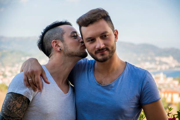 Gay couple walking in park and kissing
