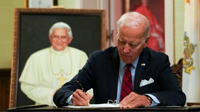 U.S. President Joe Biden signs a book of condolences for former Pope Benedict, in Washington