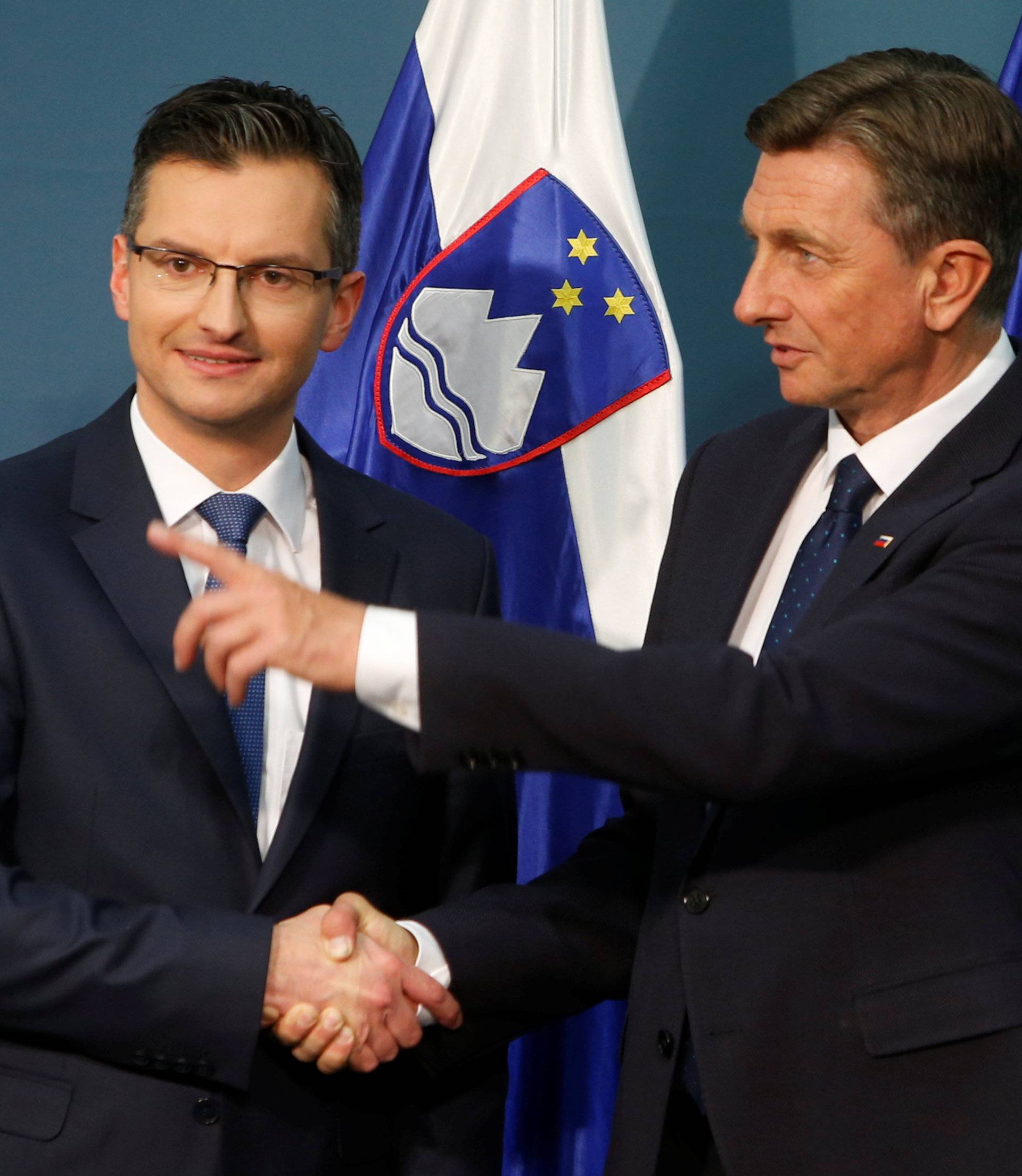 Presidential candidates Borut Pahor and Marjan Sarecreacts shake hands after first results of the second round of the presidential elections in Ljubljana
