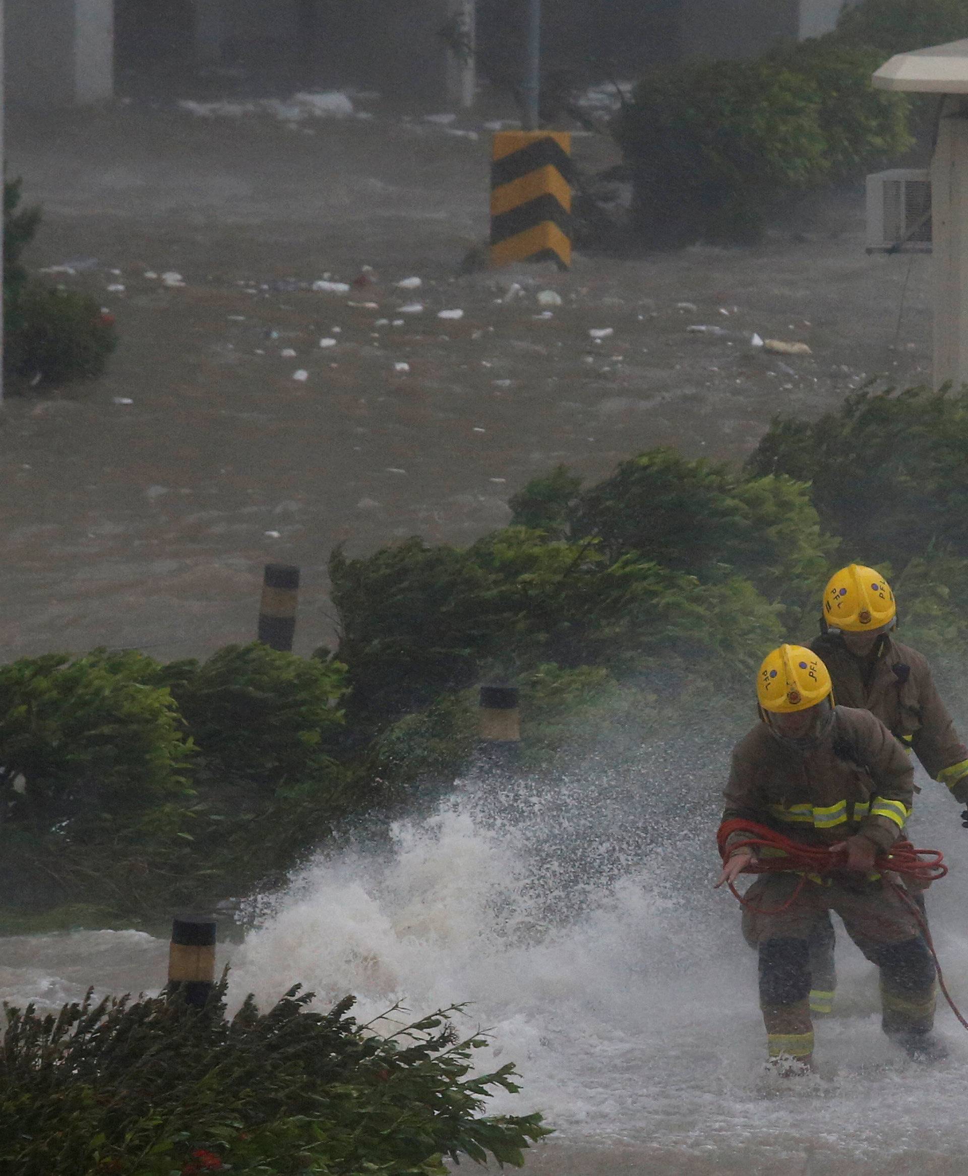 Fightfighters brace themselves as high waves hit the shore at Heng Fa Chuen, a residental district near the waterfront, during Typhoon Mangkhut in Hong Kong