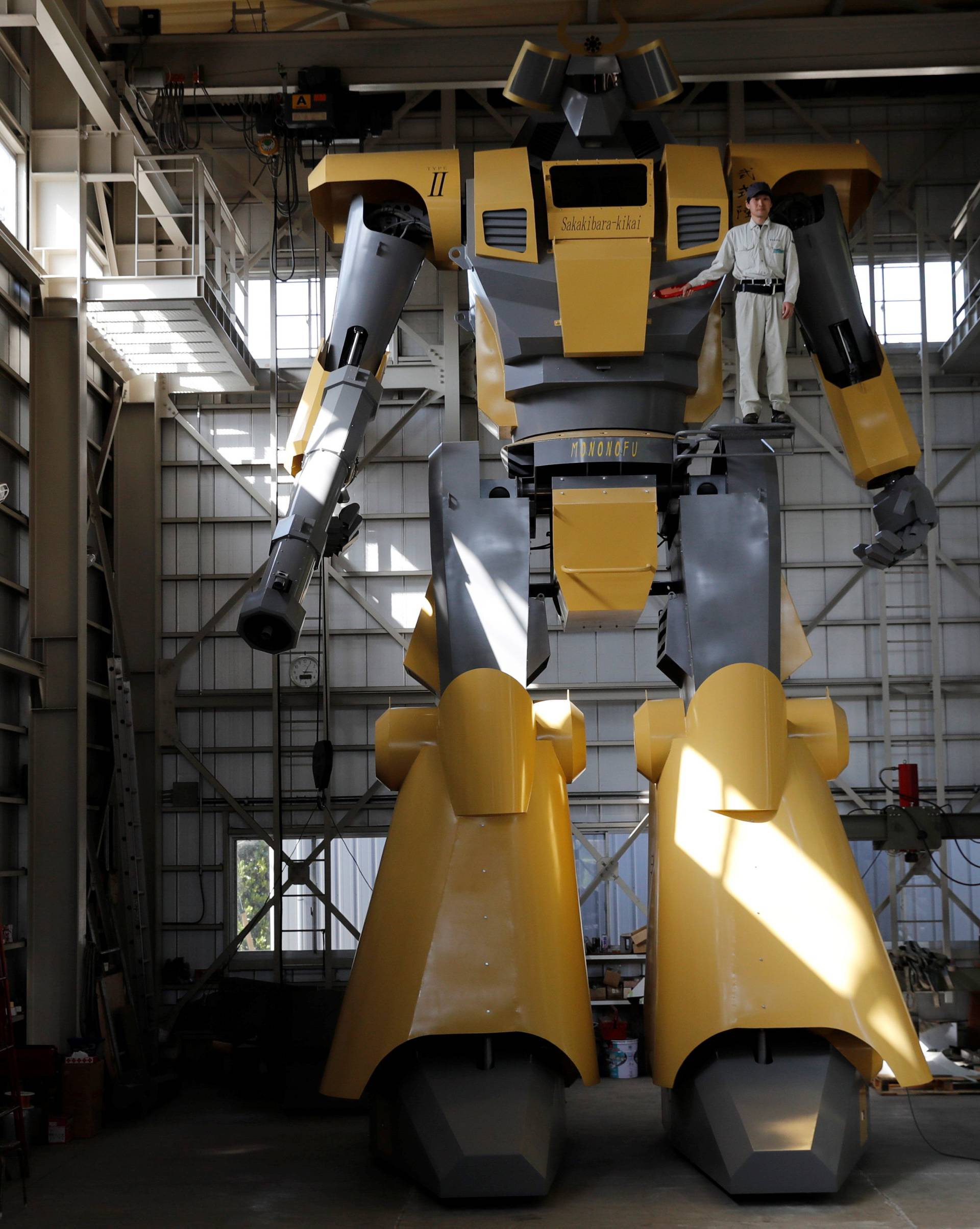 Sakakibara Kikai's engineer Go Sakakibara poses with the bipedal robot Mononofu during its demonstration at its factory in Shinto Village