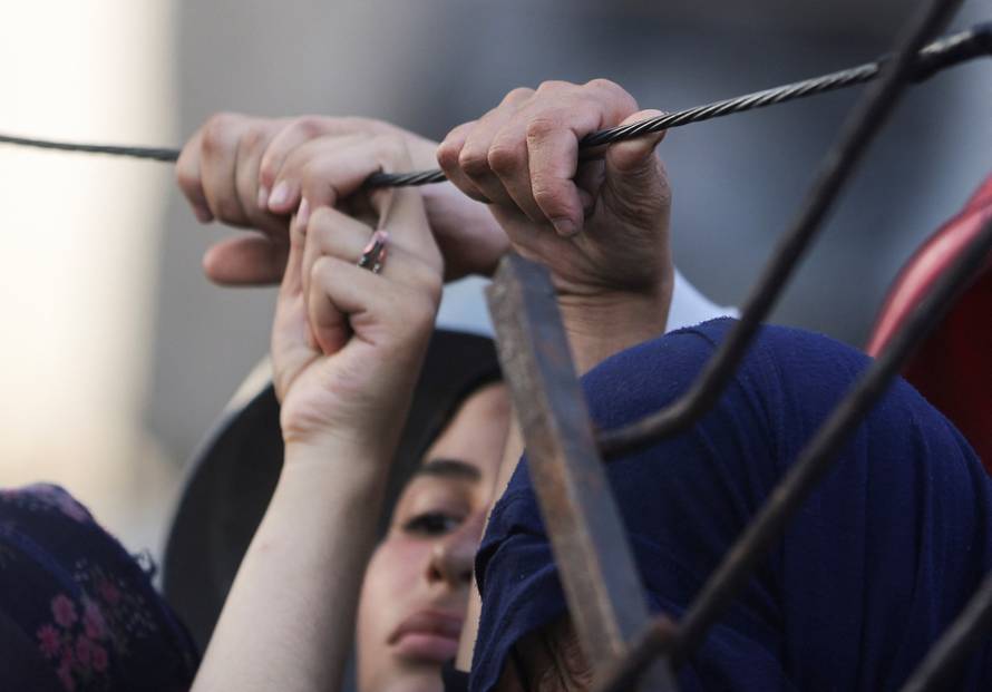 Palestinians wait to receive food from a charity kitchen, amid a hunger crisis, in Gaza City