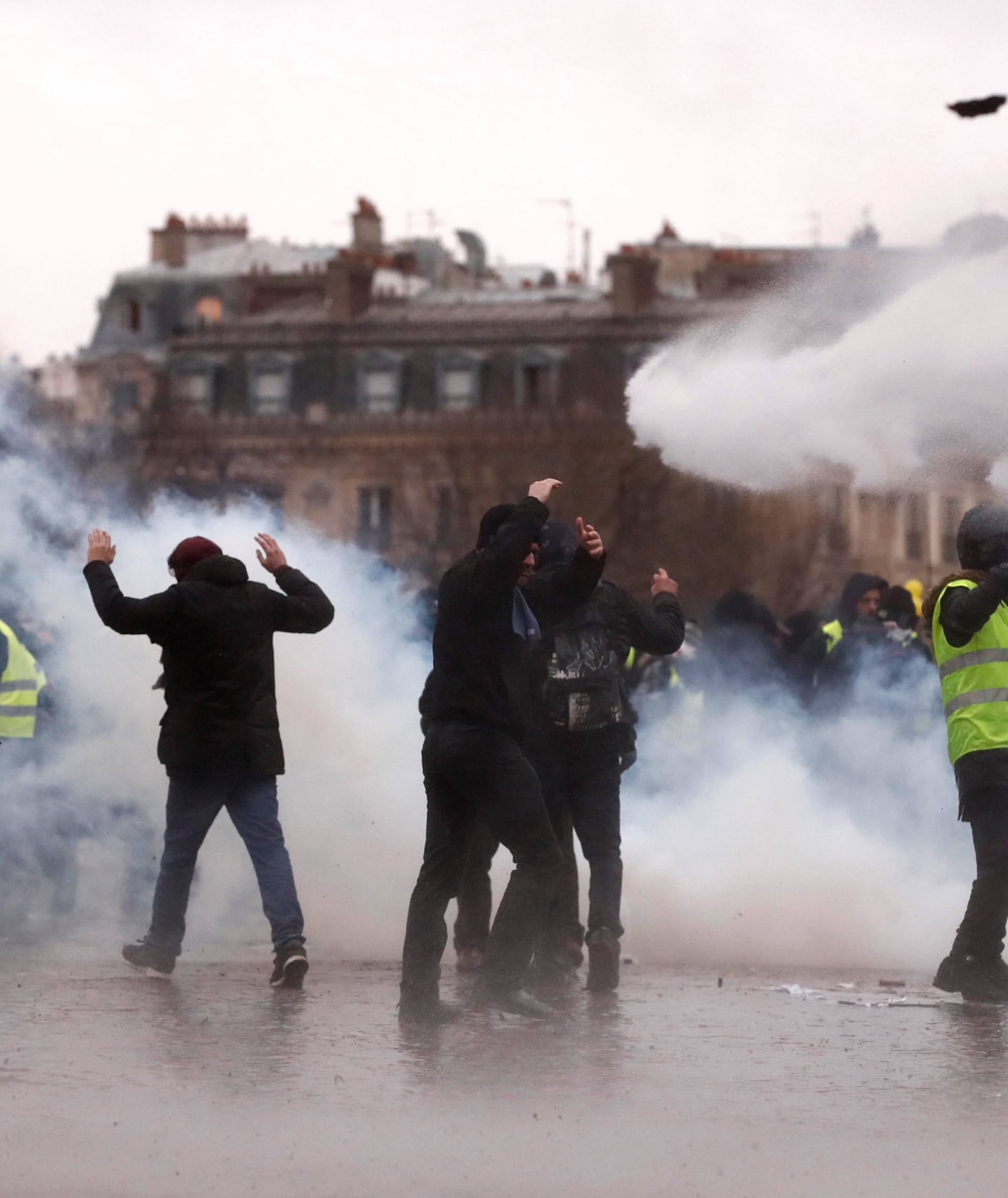 Protesters walk through tear gas during a demonstration of the "yellow vests" movement near the Arc de Triomphe in Paris