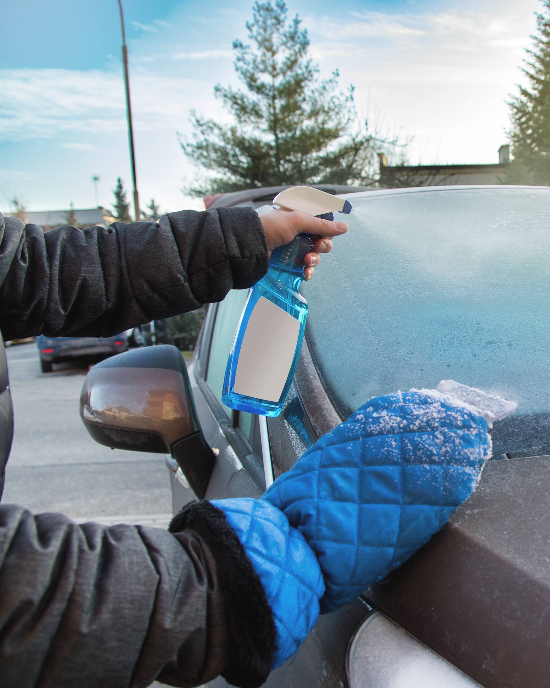 Man uses defroster spray to remove frost