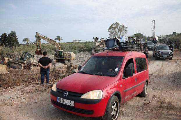 Displaced people cross the bridge linking southern Lebanon to the rest of the country, which was hit earlier in an Israeli strike, in Qasmiyeh