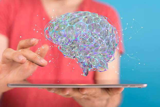 Closeup of a 3d rendered brain hologram hovering over a laptop held by a woman