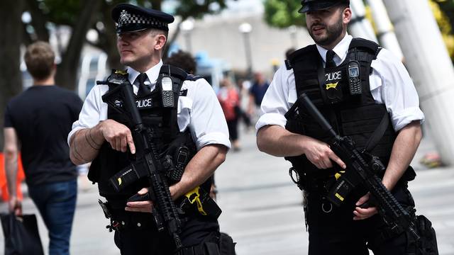 Armed police officers walk along the South Bank in London