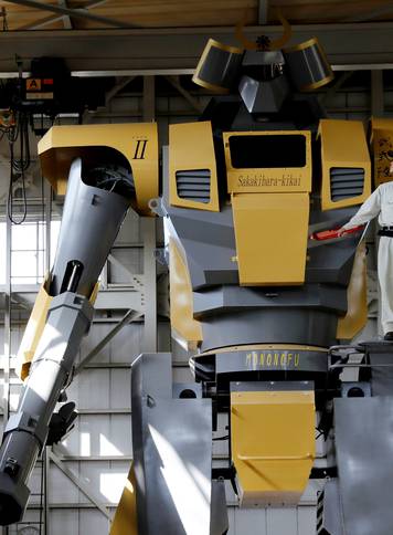 Sakakibara Kikai's engineer Go Sakakibara poses with the bipedal robot Mononofu during its demonstration at its factory in Shinto Village