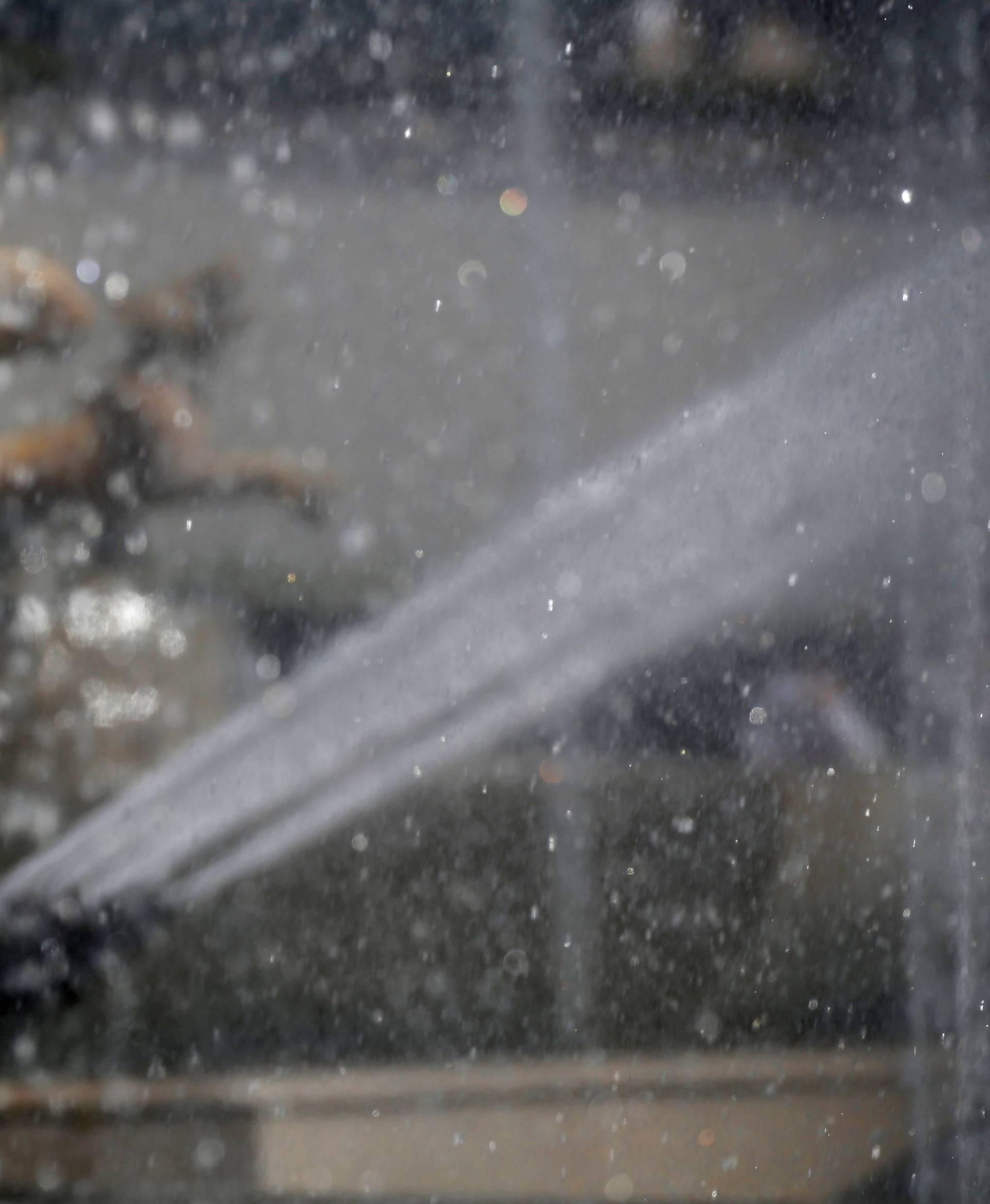 A woman cools off in a fountain as a summer heatwave with high temperatures continues in Paris