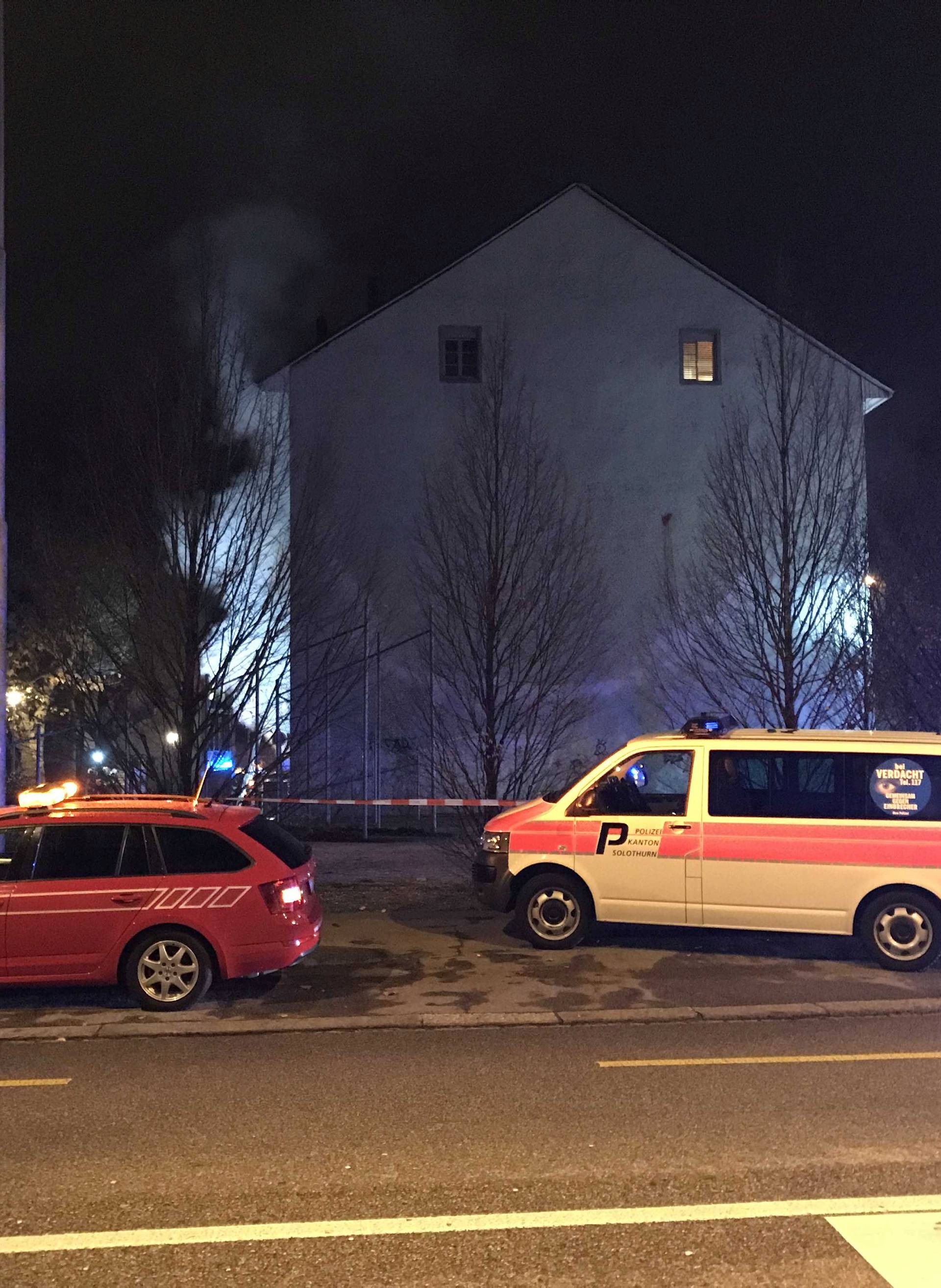 Operational vehicles of police and firefighters are seen in front of a house where six people were killed in an apartment fire early on Monday morning, police said in Solothurn