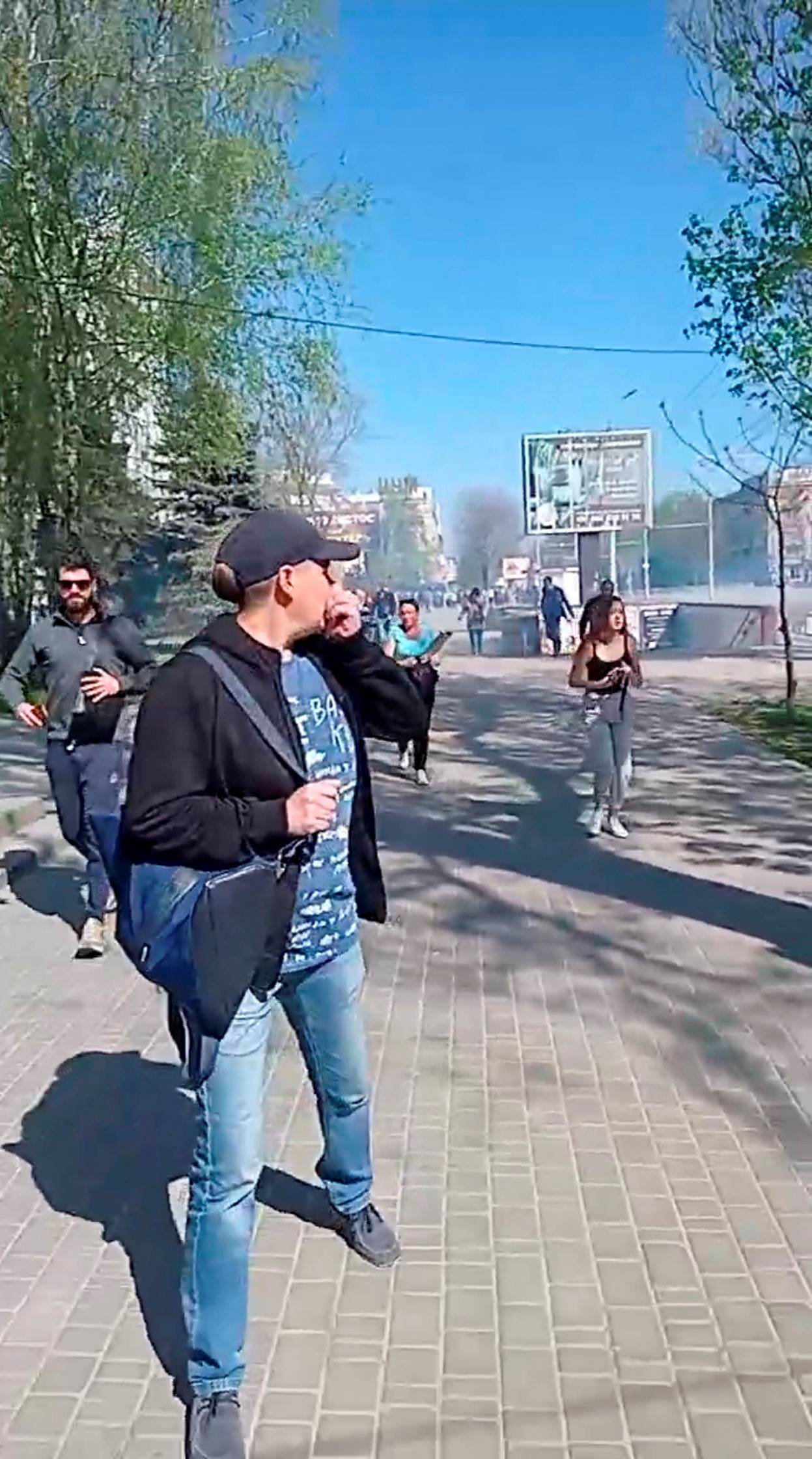 People run away from tear gas during a protest, amid Russia's invasion of Ukraine, in Kherson