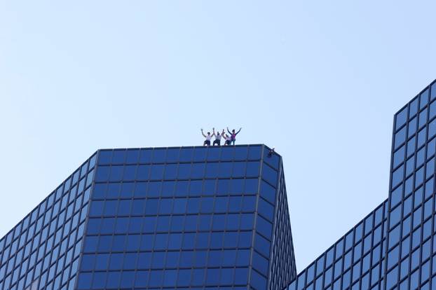French Spiderman Alain Robert and climbers Martin Banot, Alexis Landot and Leo Urban climb a skyscraper in La Defense near Paris