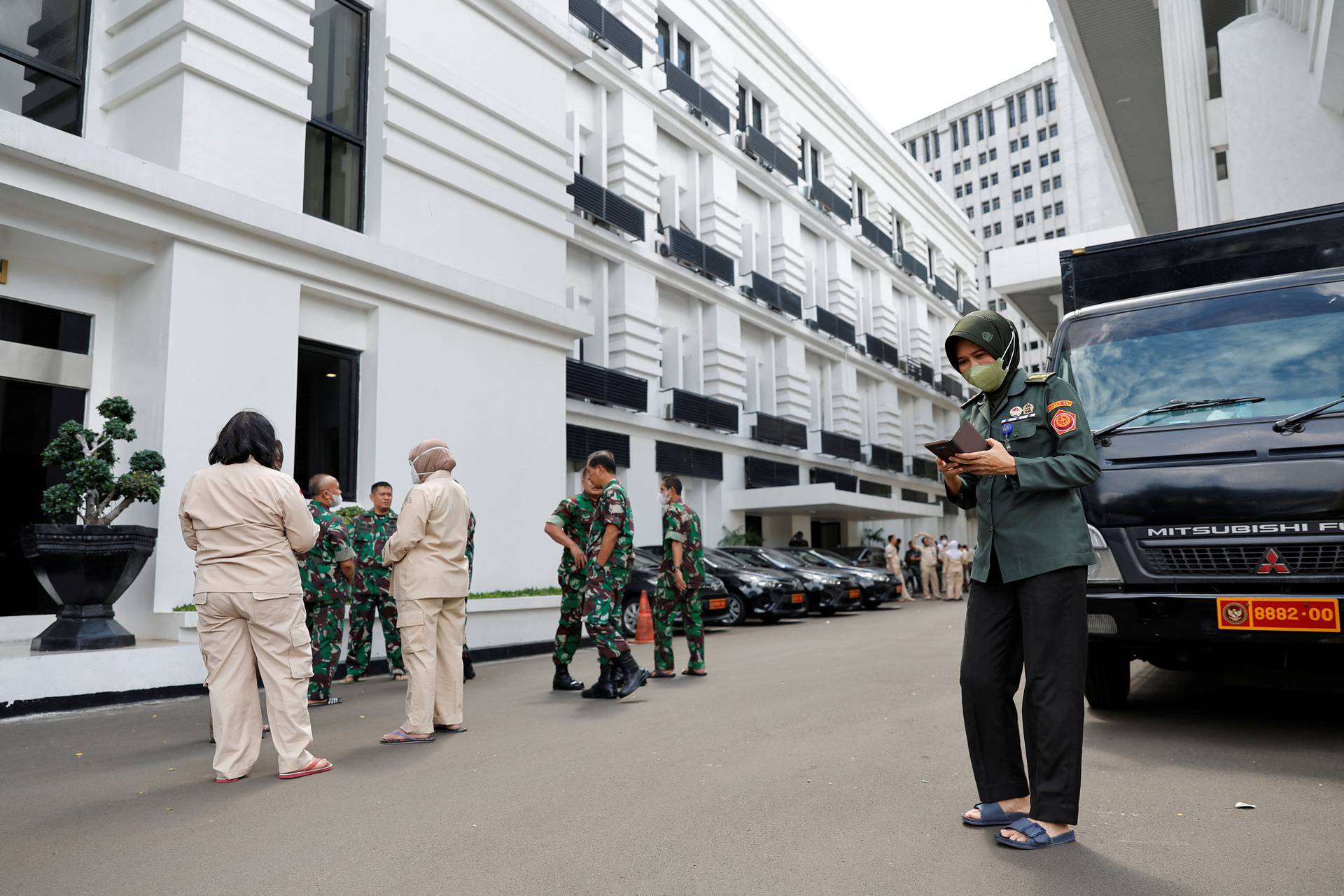 People gather outside the Indonesia's Defense Ministry buildings following an earthquake in Jakarta