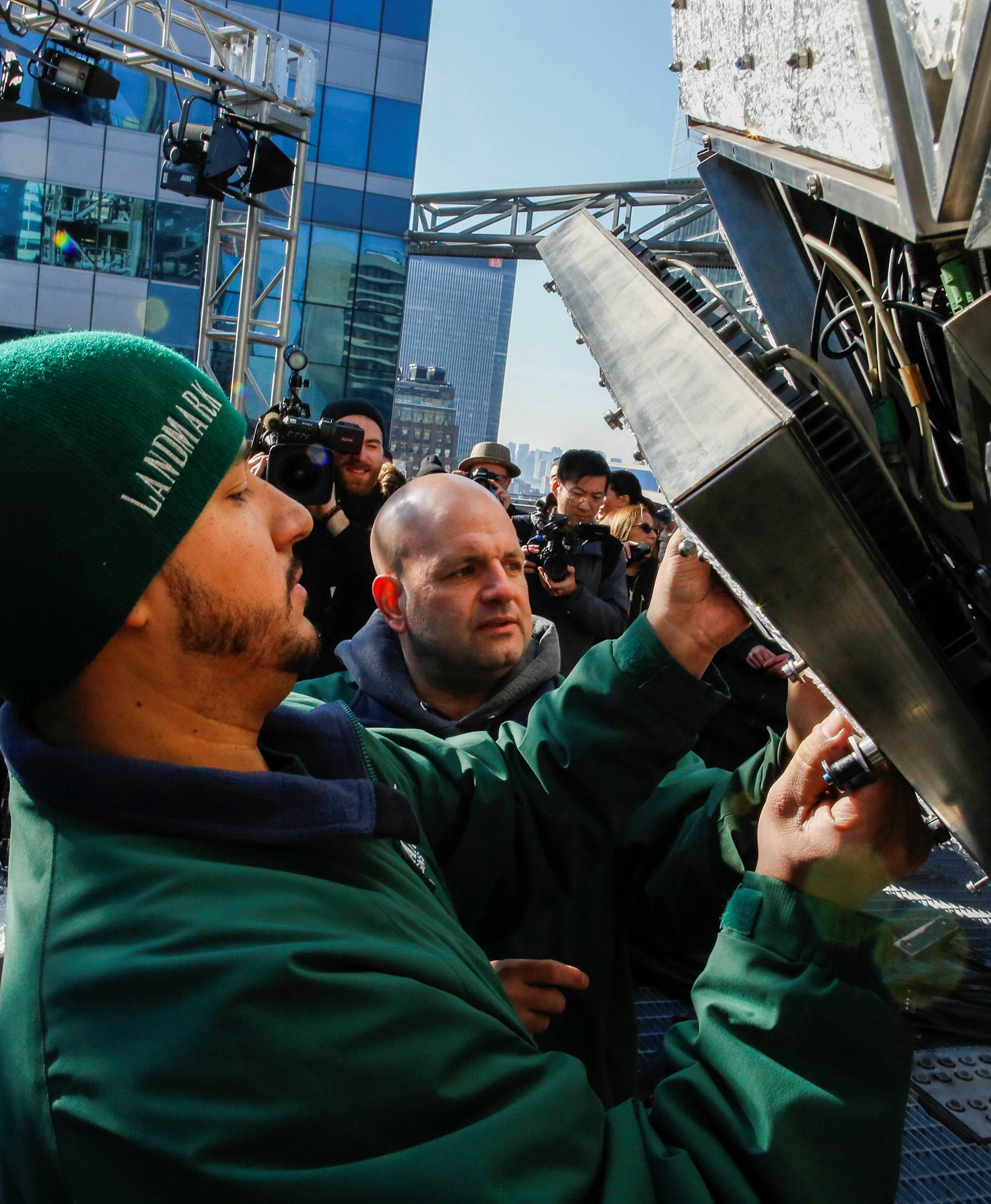 Workers install Waterford Crystal triangles on the Times Square New Year's Eve Ball on the roof of One Times Square in the Manhattan borough of New York